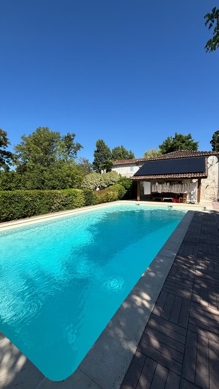 Pool-house équipé de panneaux, au bord d'une piscine
